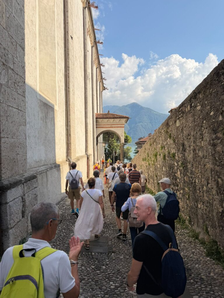 Il gruppo delle Camminate culturali tra le vie acciottolate del borgo di Lovere, con il lago d'Iseo sullo sfondo