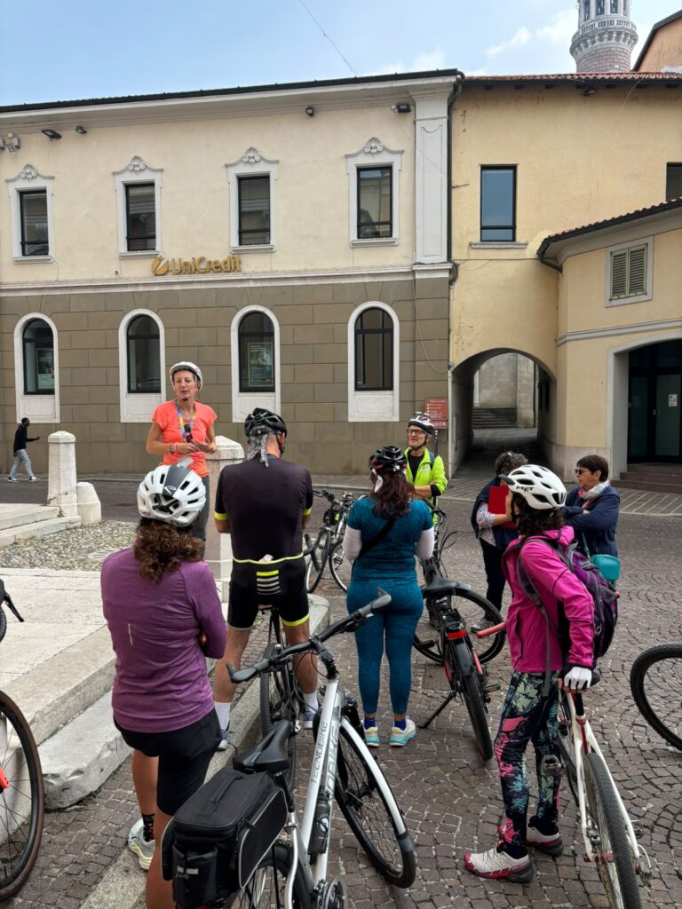 La guida racconta la storia del borgo ai partecipanti della pedalata