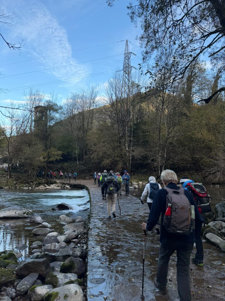 I partecipanti di «Sulle orme dei sandali» attraversano il torrente lungo il cammino